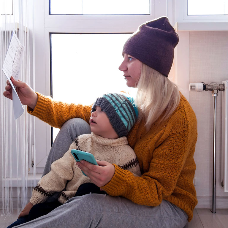 Mother with child struggling to pay heating bills