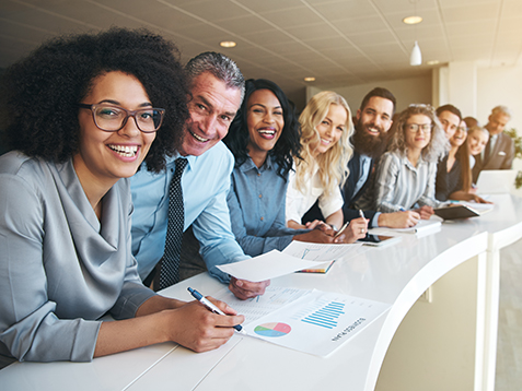 Smiling black and white coworkers looking at camera in the office.