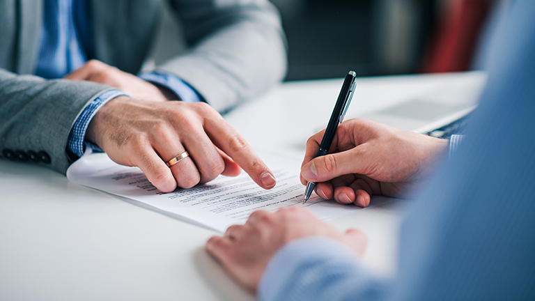 Businessmen hand's pointing where to sign a contract, legal papers or application form. 