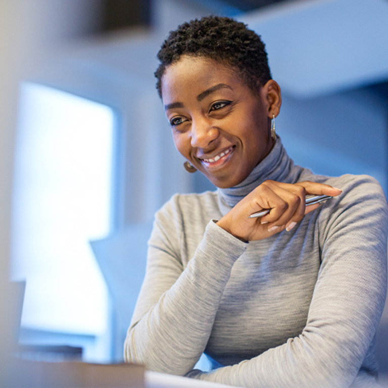 Confident african businesswoman sitting at her desk. Happy female professional working at her desk.