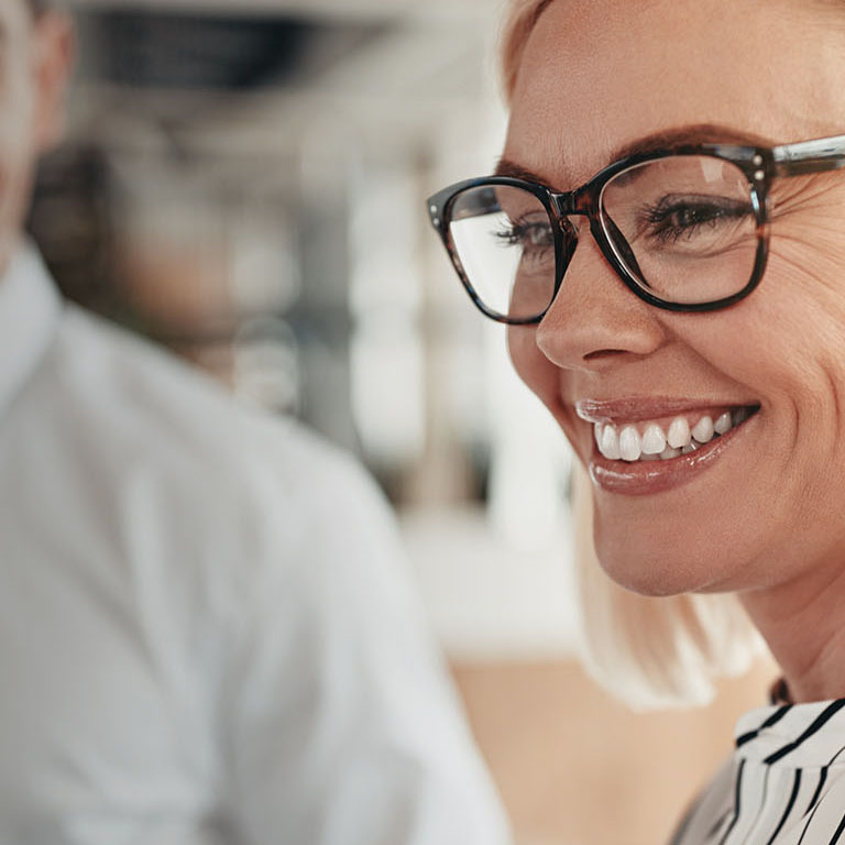 Smiling young businessman talking with colleagues during their coffee break together in a bright modern office