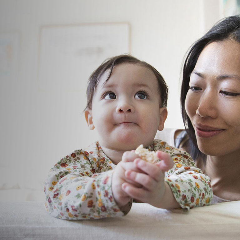 Young East Asian mother with child smiling