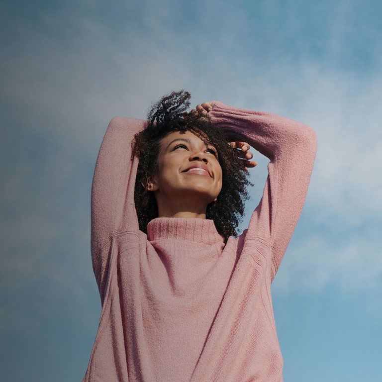 Portrait of happy young woman enjoying sunlight