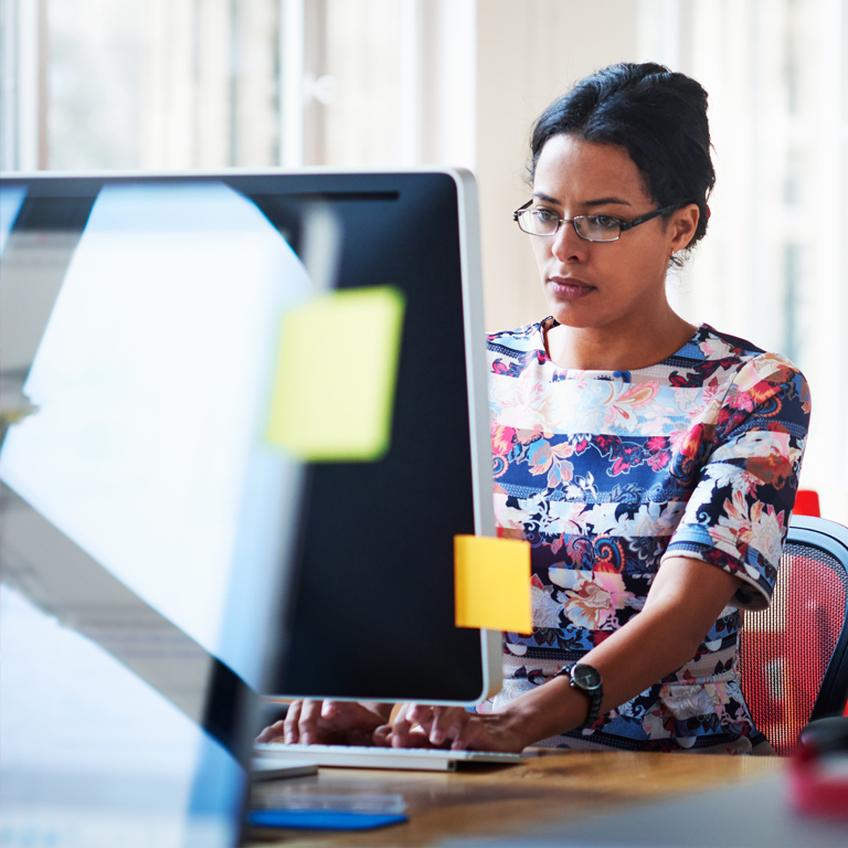 Woman with glasses in front of a computer