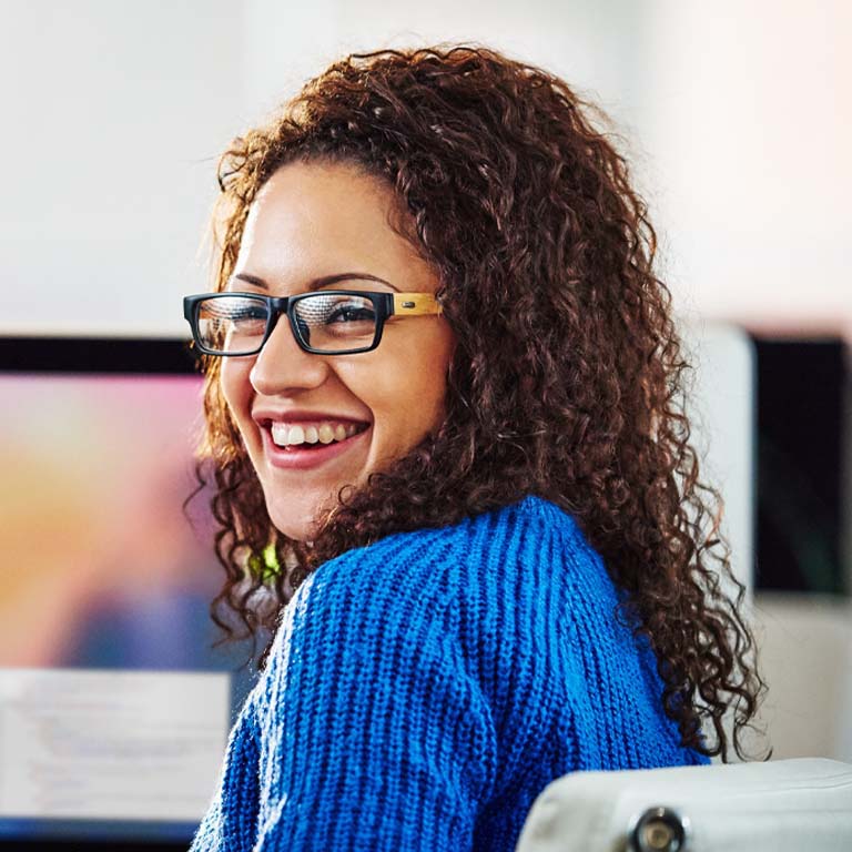 Co-workers in office happily discussing the details of a project