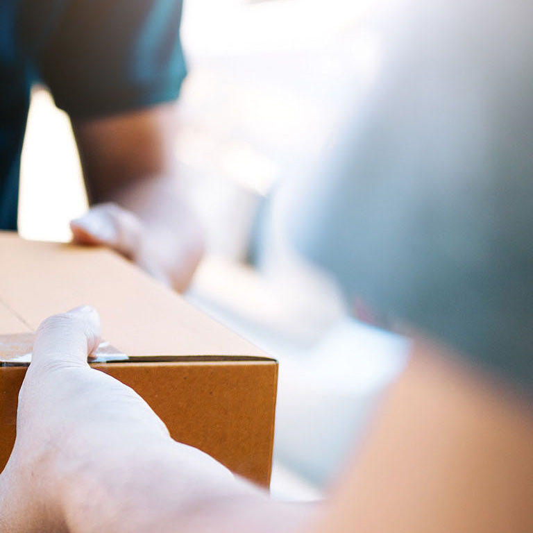 Close up of hands cargo staff are delivering cardboard boxes with parcels inside to the recipient's hand.