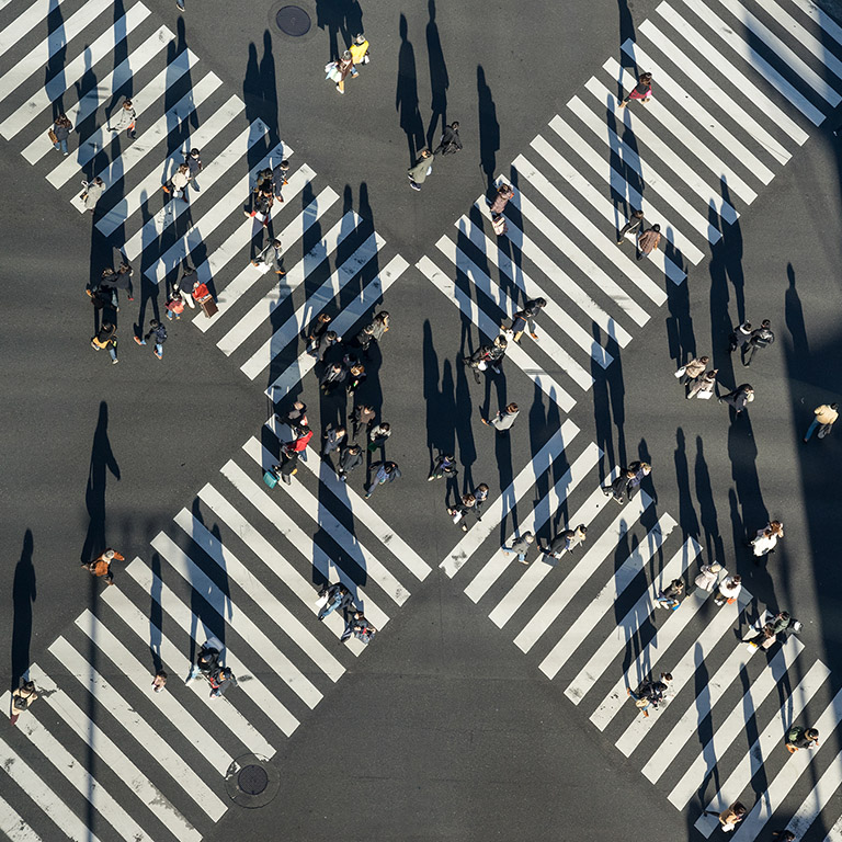 Aerial view of people passing crosswalk in the downtown street.