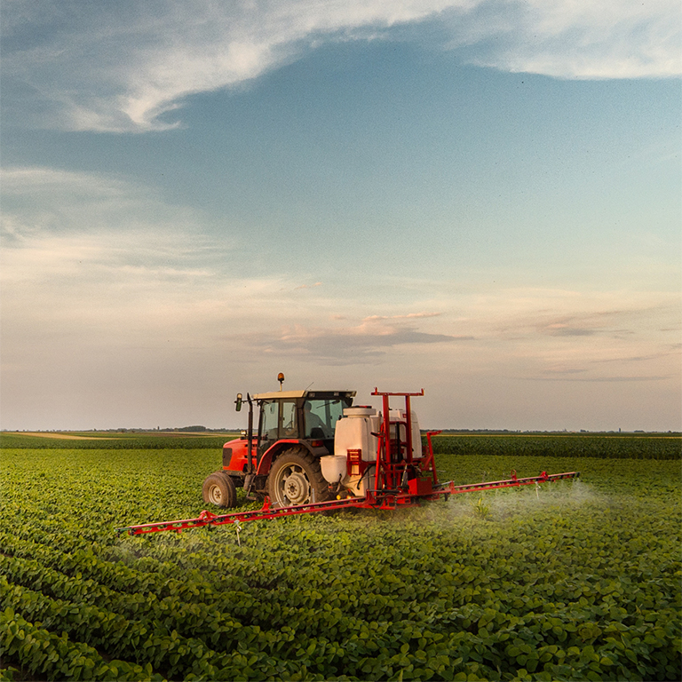 Tractor spraying pesticides at  soy bean fields