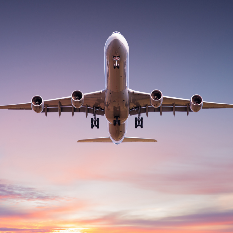 Airplane flying above clouds in beautiful sunset