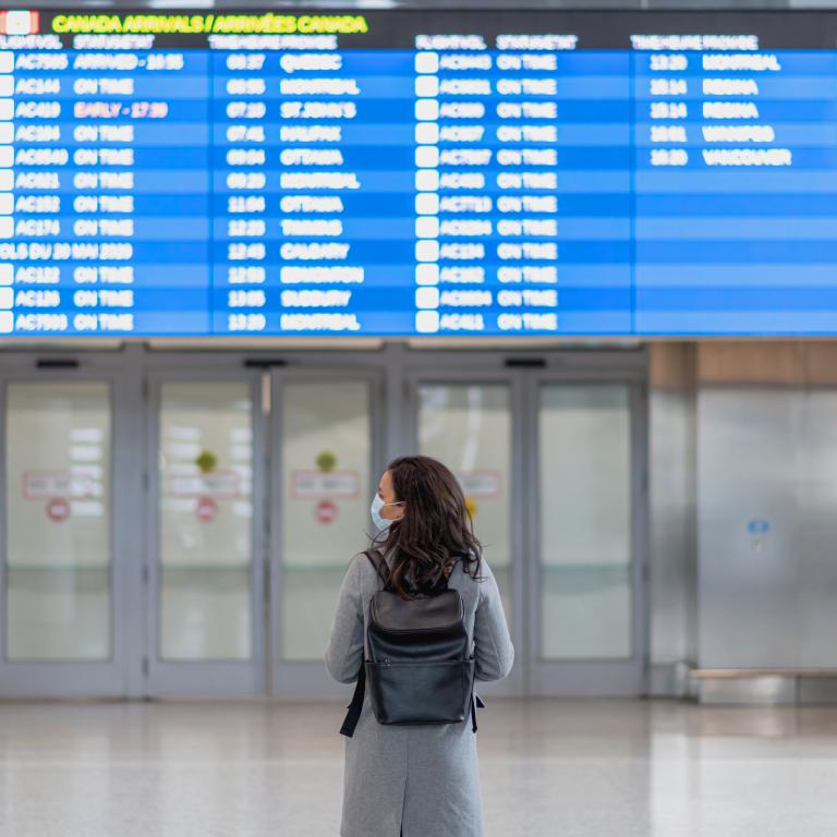 Airport traveler checks flight schedules during afternoon hours