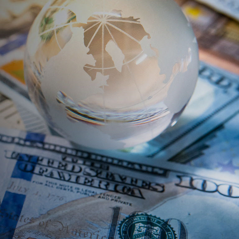 Global business and economy. World globe crystal glass on various international money banknotes. Currency exchange rate. Financial investment concept