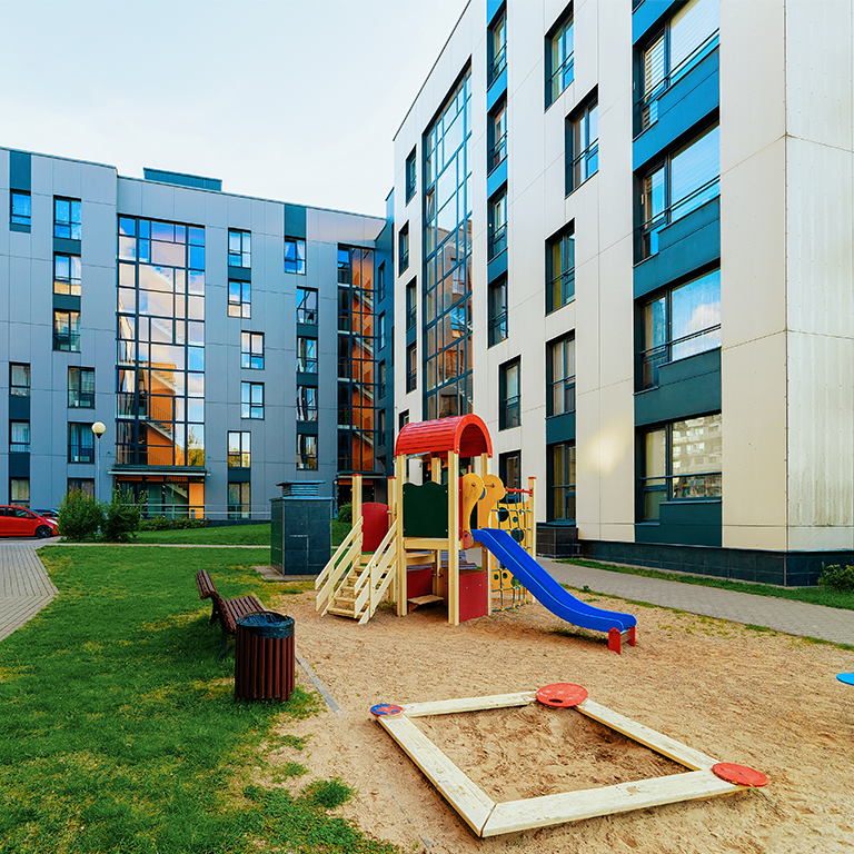 Modern residential apartment flat house building and children playground. With outdoor facilities concept.