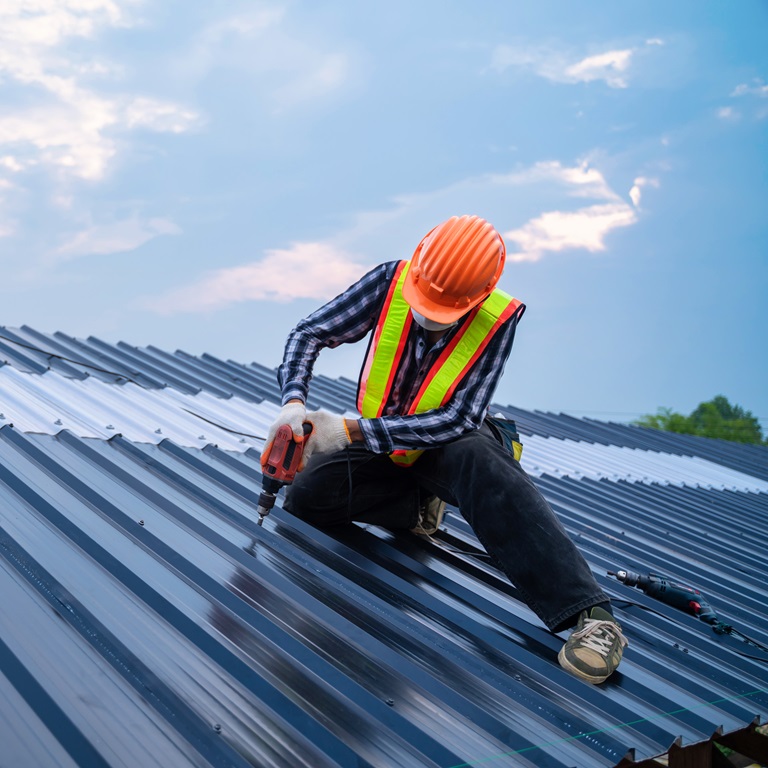 Asian roofer worker safety wear using air or pneumatic nail gun 