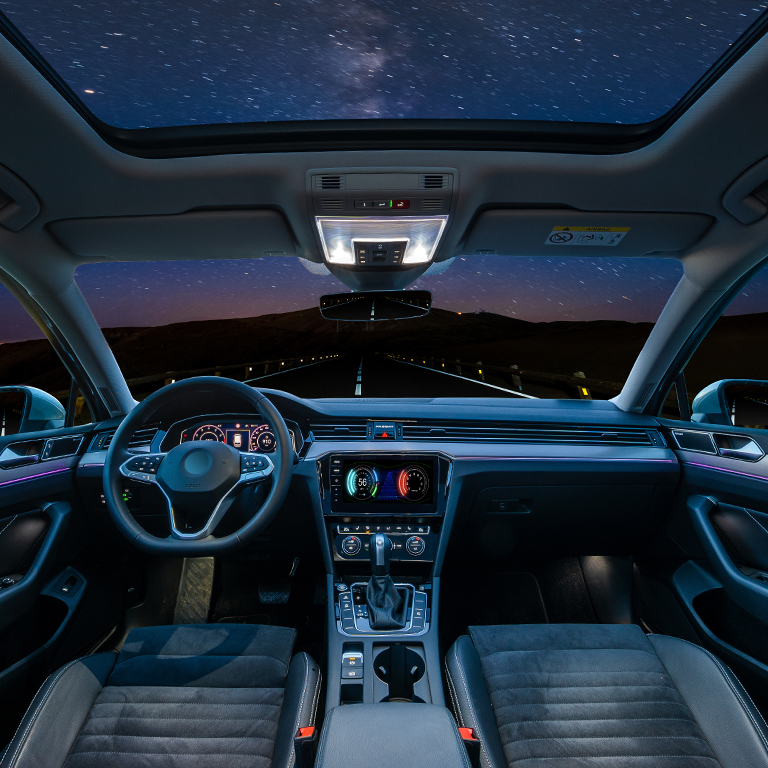 car is in autonomous driving mode with a panoramic glass roof while driving at night in the mountains