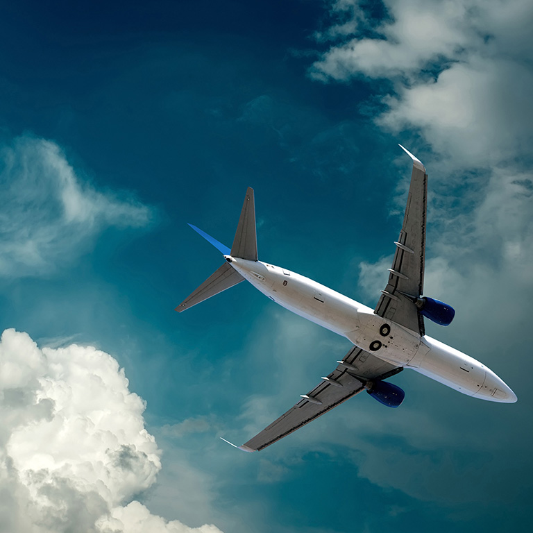 Airplane at flying under sky with clouds