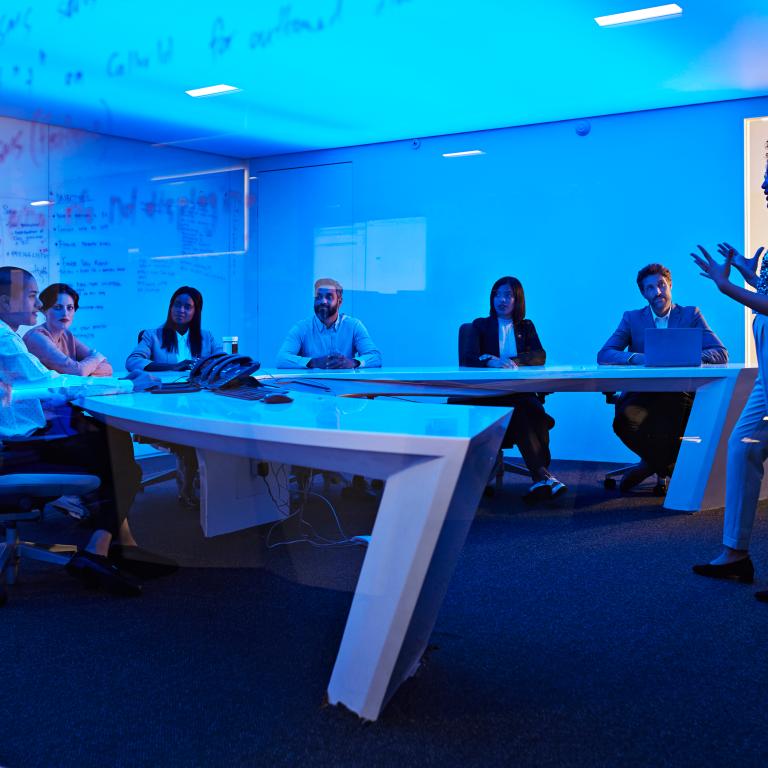 Business meeting with team in blue-lit conference room