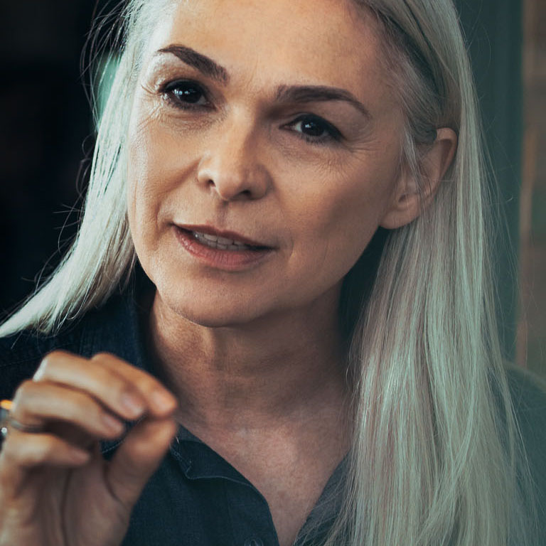 Senior business woman explaining business matters to her team in a meeting . Mature female manager advising her colleagues in meeting.