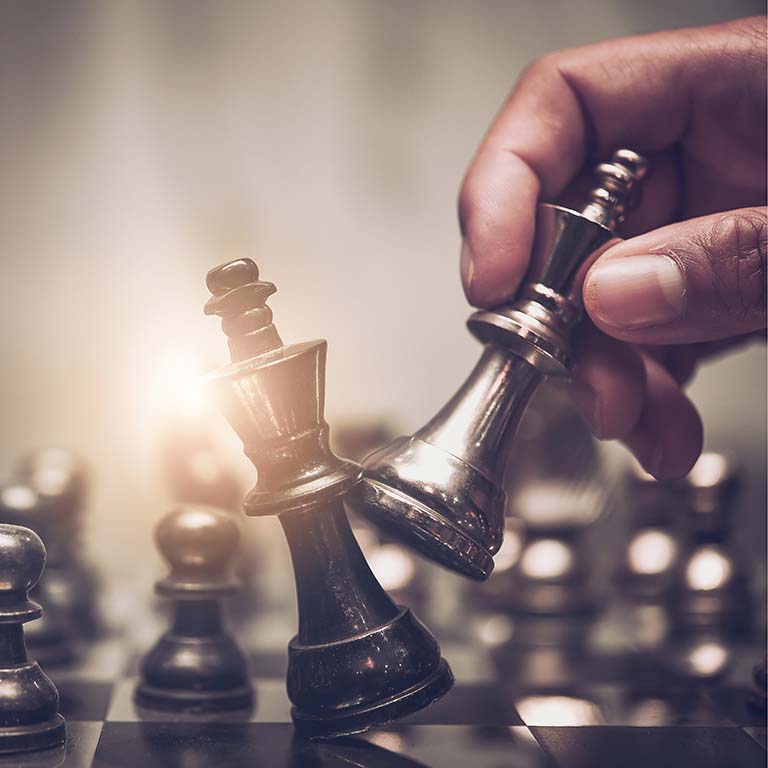 Business man moving chess piece on chess board game