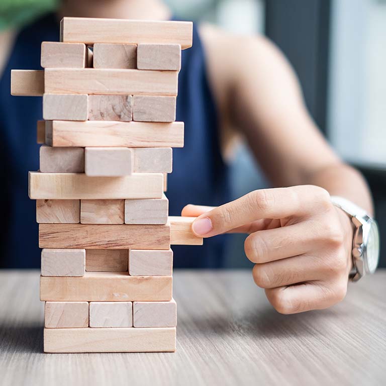 Businesswoman hand placing or pulling wooden block on the tower. Business planning, Risk Management, Solution and strategy Concepts