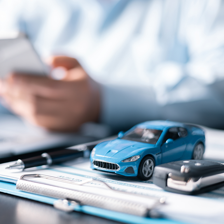 Car toy beside man using mobile phone