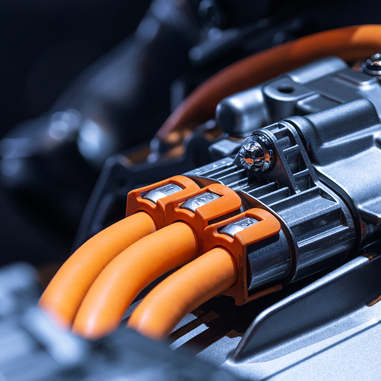 Chassis of the electric car with powertrain and power connections closeup. Blue toned. EV car drivetrain at maintenance