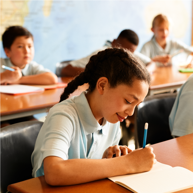 Children writing in notebooks in class
