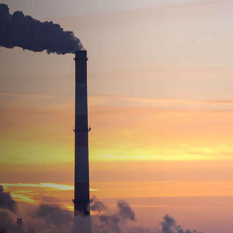 Emission to atmosphere from industrial pipes. Smokestack pipes shooted at sunrise. Global warming concept and air pollution