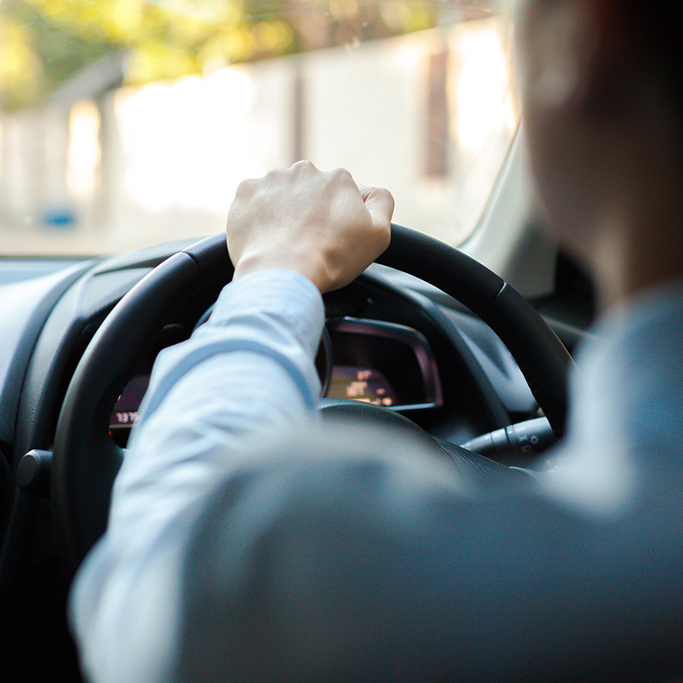 Close-up of a person driving in a car on the road