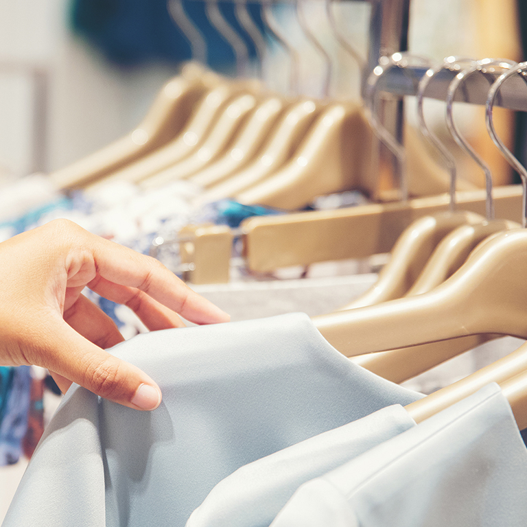 Hand of customer choosing clothes in a clothing store