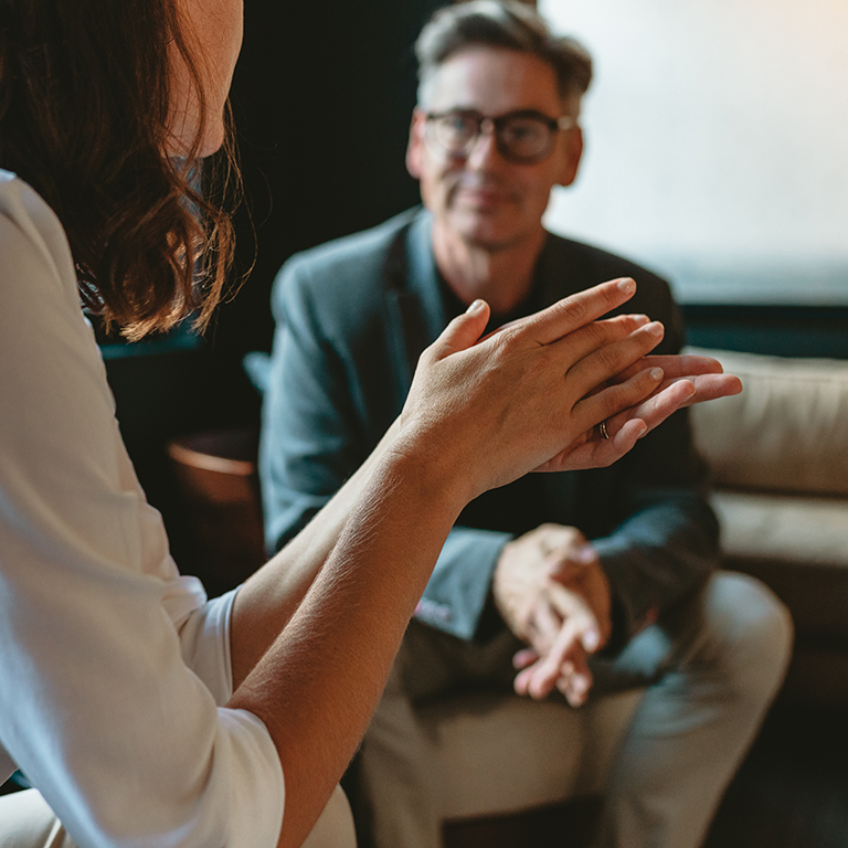 Two business people discussing in office lounge. Businesswoman talking with a male colleague in office.