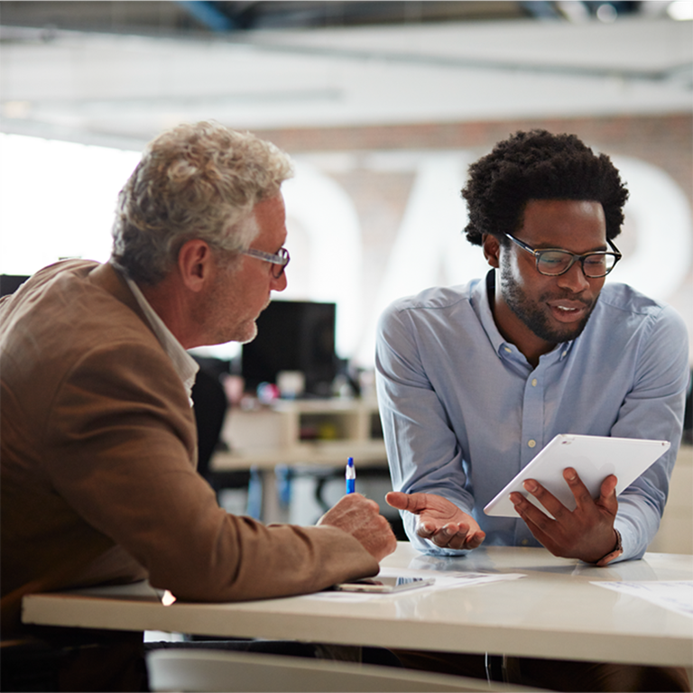 Colleagues talking about news from a tablet