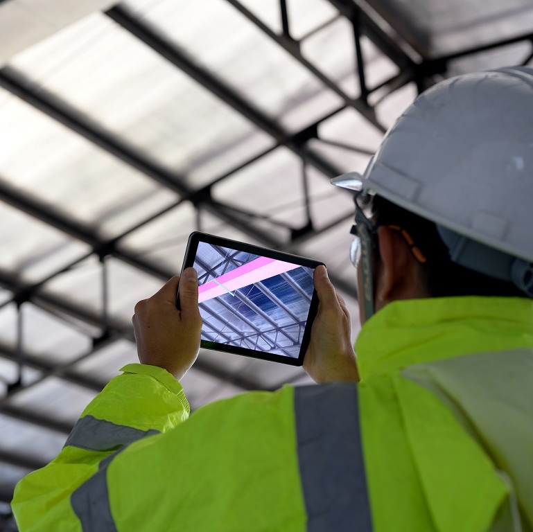 Construction Civil Engineer use technology software through tablets to scan building construction and inspection to show augmented reality in work, Building information model or BIM concept