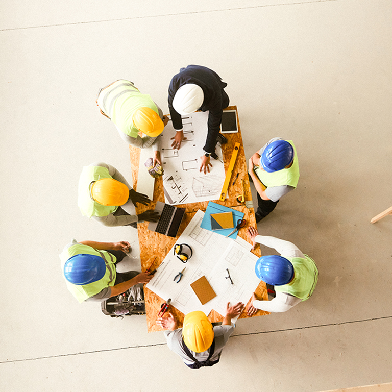Construction team collaborates on building plans inside site