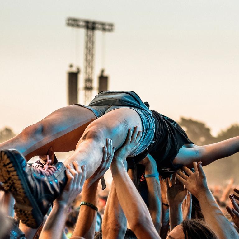 Crowd lifts person during outdoor music event