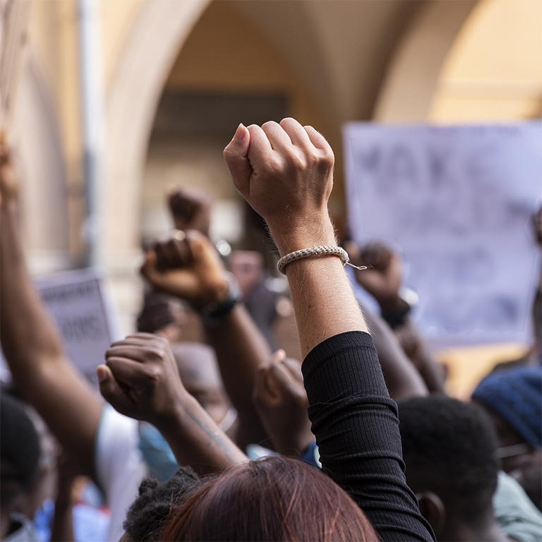 People raising fist with unfocused background in a pacifist protest against racism demanding justice