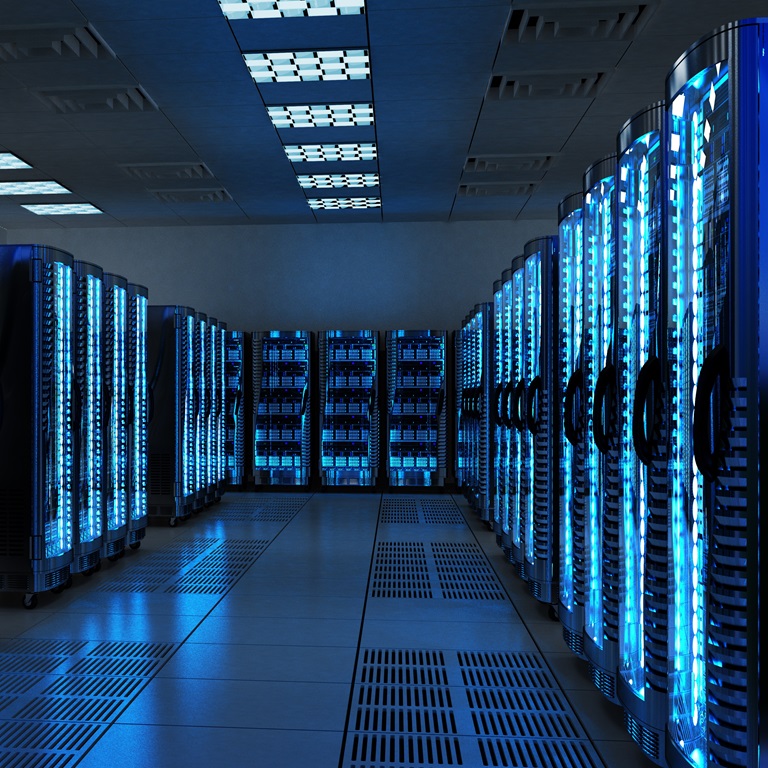 Rows of illuminated server racks fill the room, casting a blue glow. The facility operates efficiently, showcasing technology and infrastructure vital for data management at night.