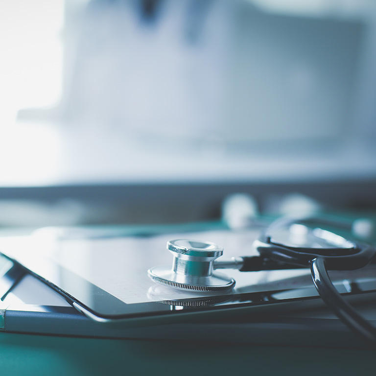 Medical equipment: blue stethoscope and tablet on white background. Medical equipment