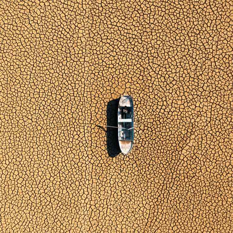 Dried lakebed with a boat