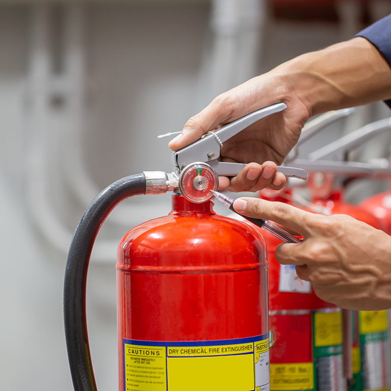 Engineer are checking and inspection a fire extinguishers tank in the fire control room for safety training and fire prevention.