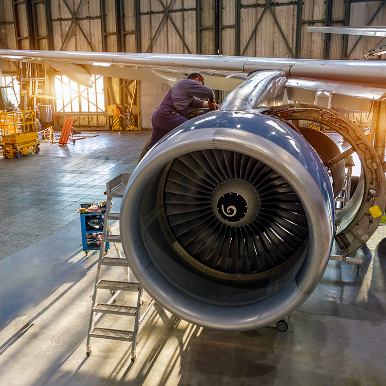 Aircraft engine repair, mechanic installs reverse hoods