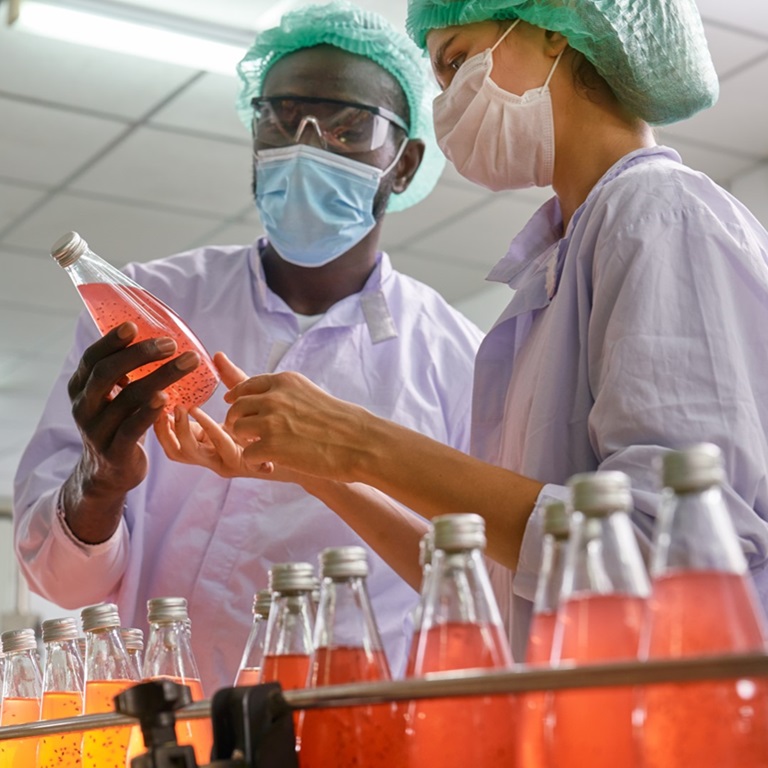 Workers check product quality on food & beverage manufacturing line