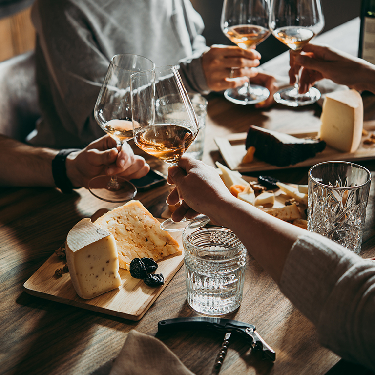 Group of people having wine and cheese in a restaurant or wine bar.