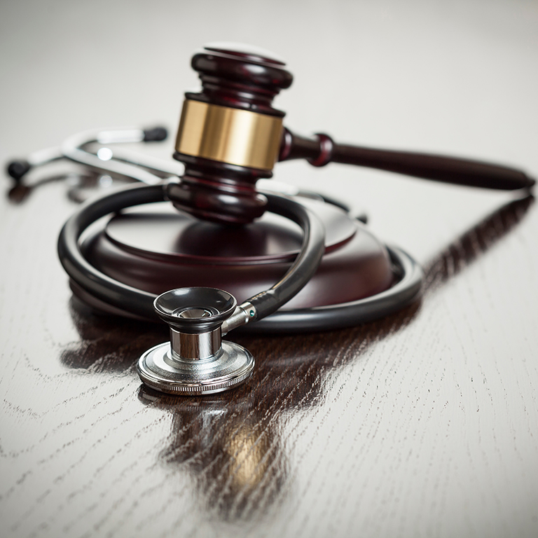 Gavel and Stethoscope on Reflective Table