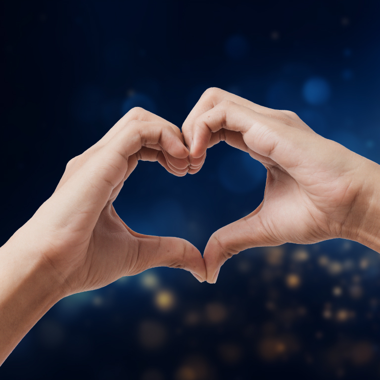 Hands making a heart shape on a blue glow bokeh background