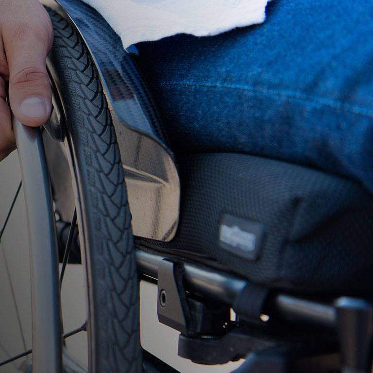 cropped image of man using wheelchair on street