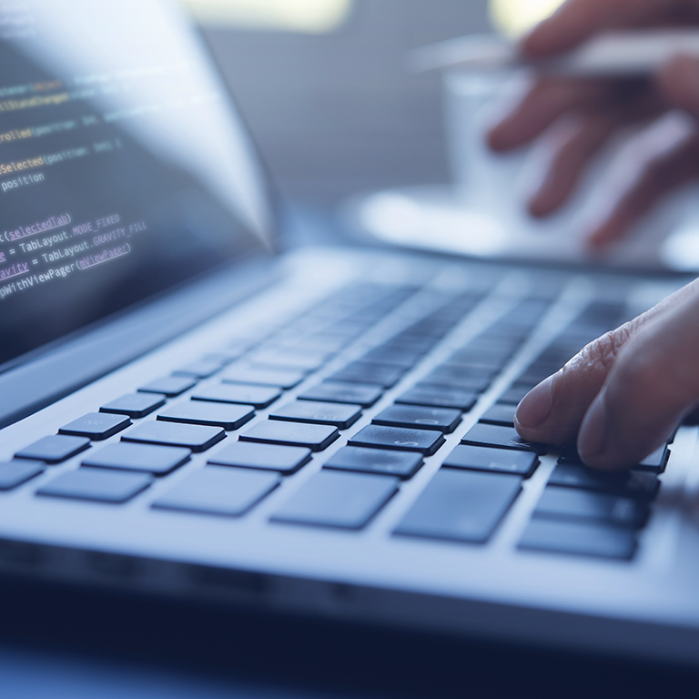 Web or application software development, business and technology concept. Programmer, man software developer hands coding HTML, programming Javascript on laptop computer screen, back view close up