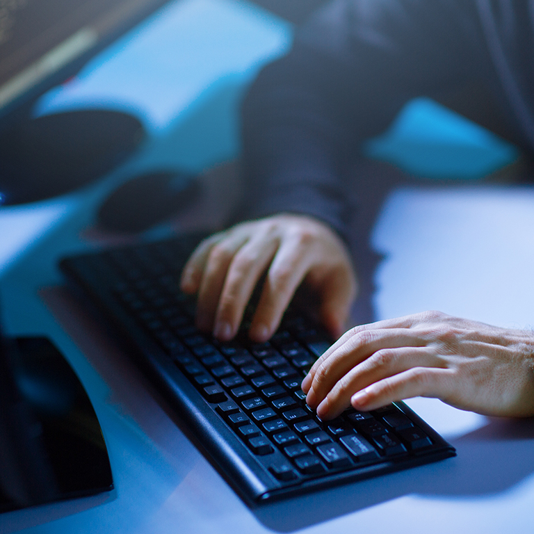 Cybercrime, hacking and technology concept - hands typing on computer keyboard