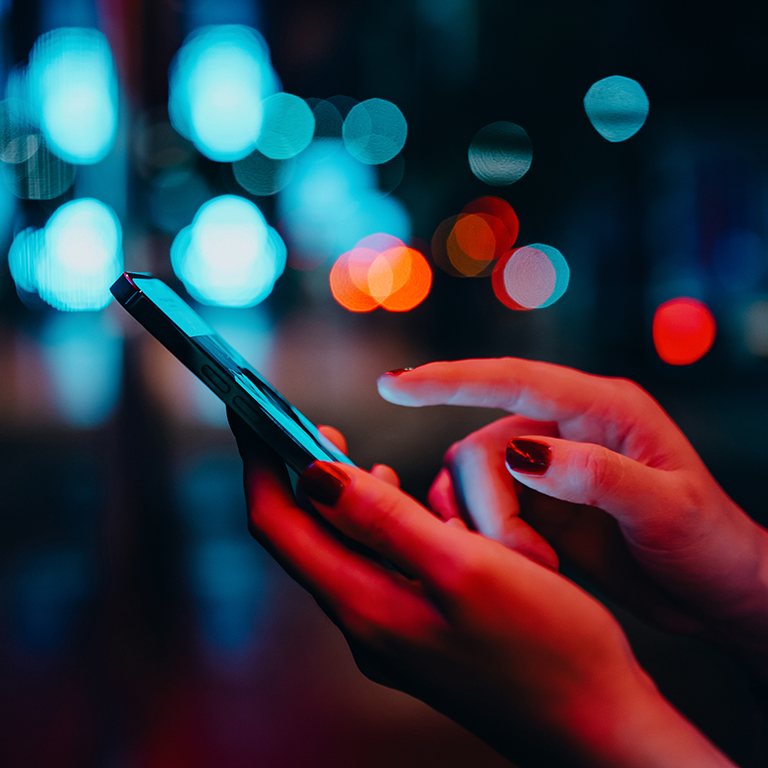 Hands using smartphone in city