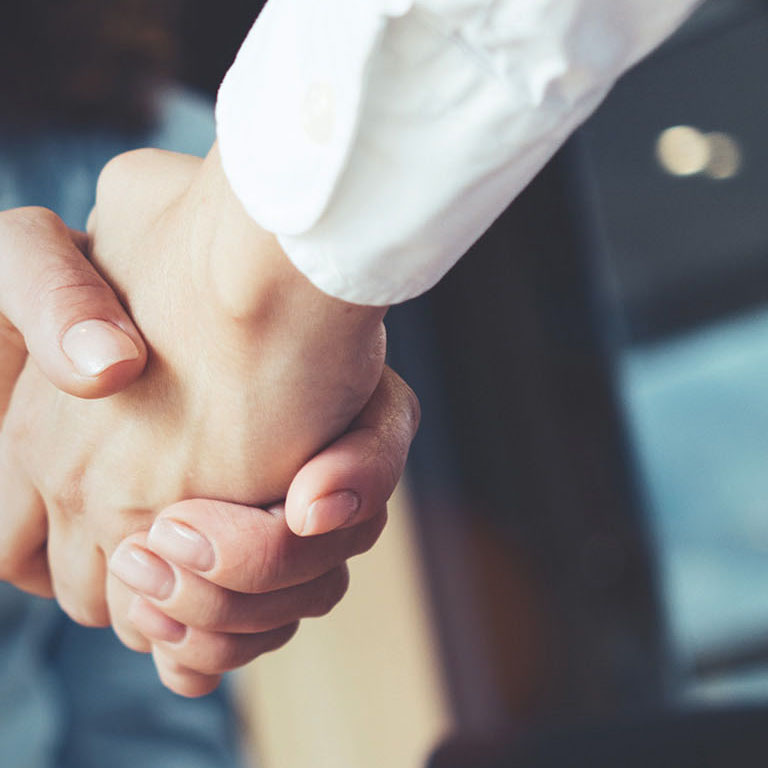 Young business people shaking hands in the office. Finishing successful meeting. Three persons