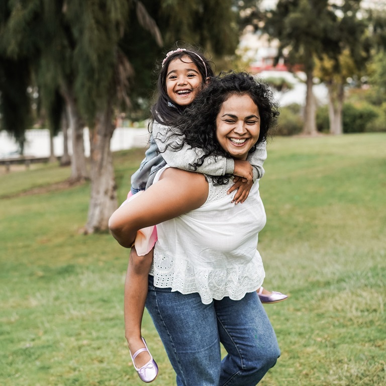 Happy Indian mother having fun with her daughter outdoor